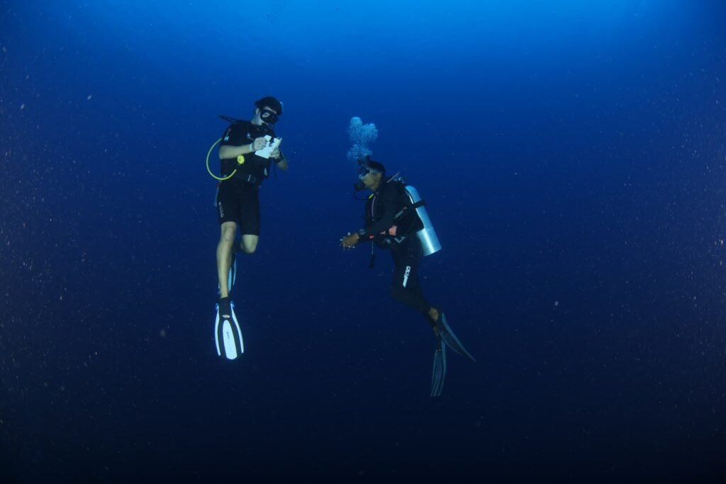 Scuba divers conducting dive skills underwater with dive instructor during PADI Advanced Open water dive course